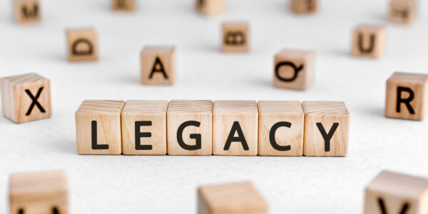 Legacy - words from wooden blocks with letters, money or property left to someone legacy concept, white background